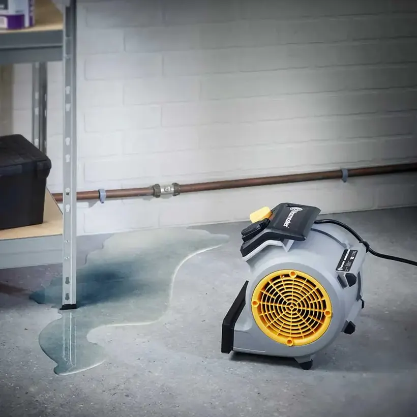 Air mover drying a South Shore basement beside a support column